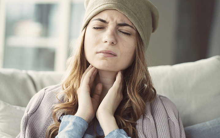 About sore throats Young Woman Having Sore Throat and Touching Her Neck With Hands