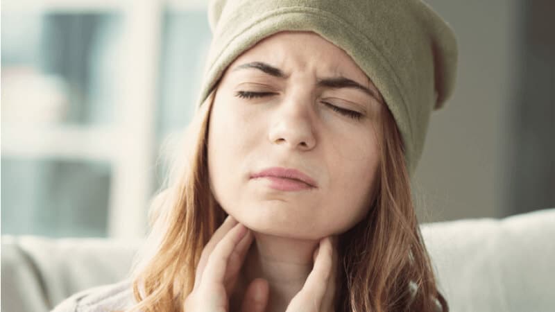Young Woman Having Sore Throat and Touching Her Neck With Hands