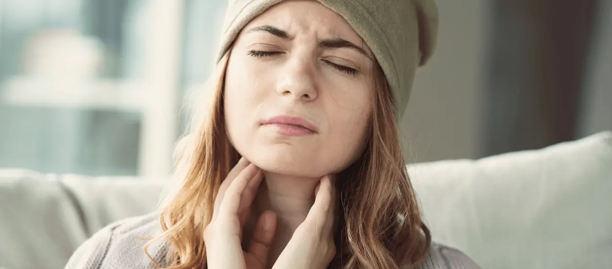 Young Woman Having Sore Throat and Touching Her Neck With Hands